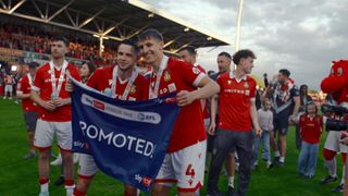 The players of Wrexham celebrating promotion on the field in Welcome to Wrexham