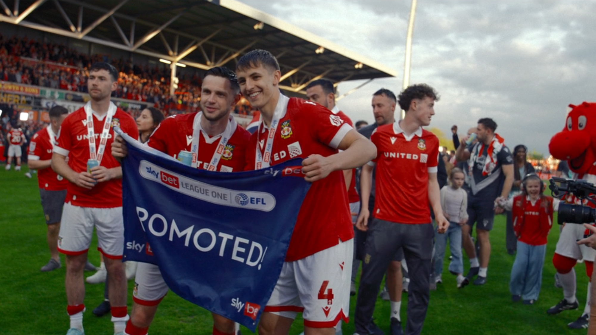 The players of Wrexham celebrating promotion on the field in Welcome to Wrexham