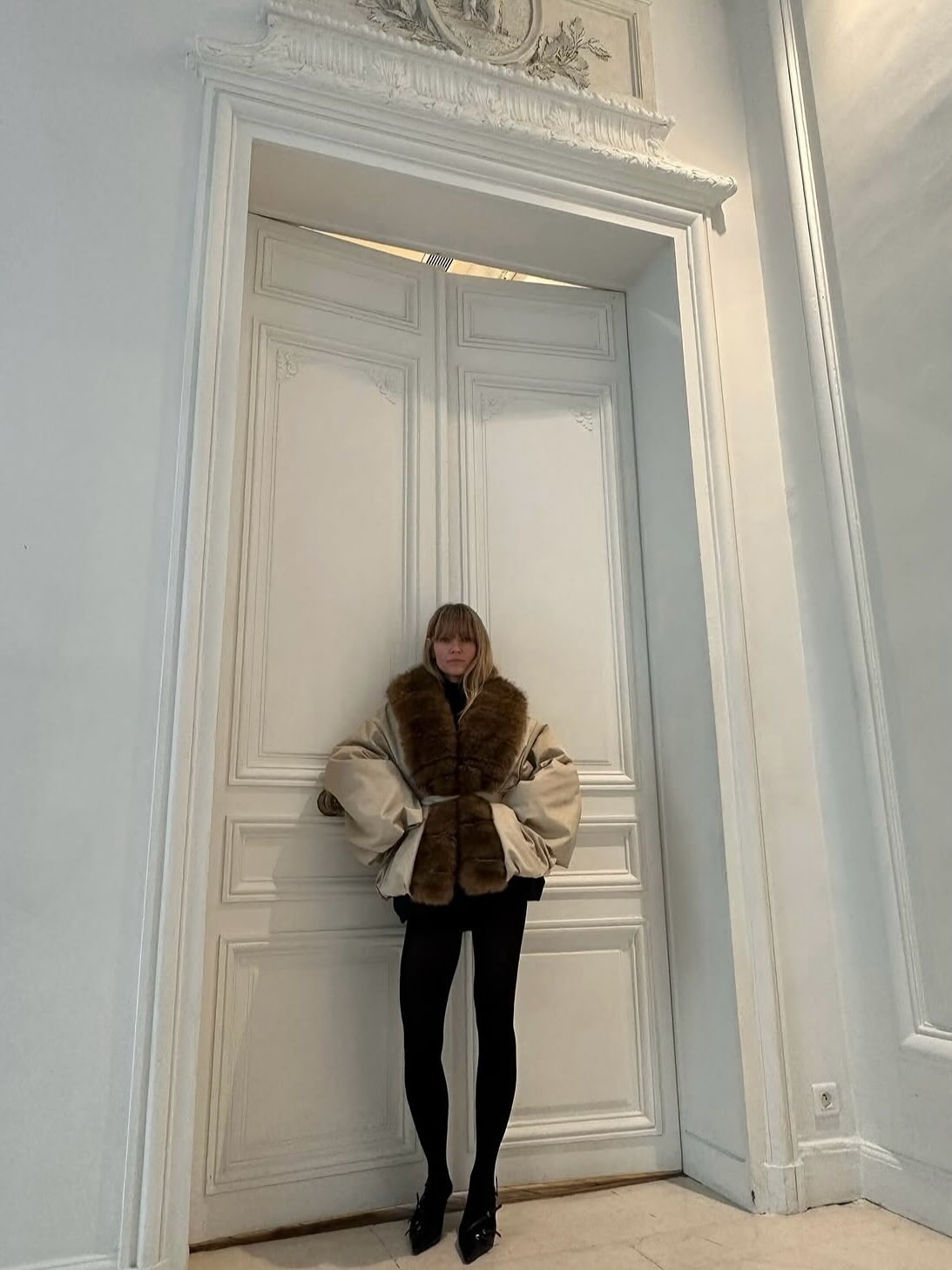 Fashion person Jeanette Madsen wears a faux fur trend 2025. She wears a shearling lined coat.