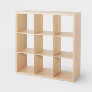 a 3 by 3 wooden shelf in the shape of cubes