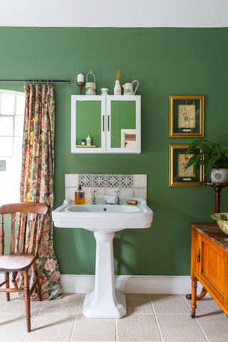 green bathroom with white basin and mirror