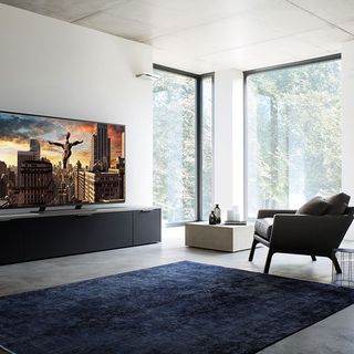 living room with white wall television sofa chair and glass window
