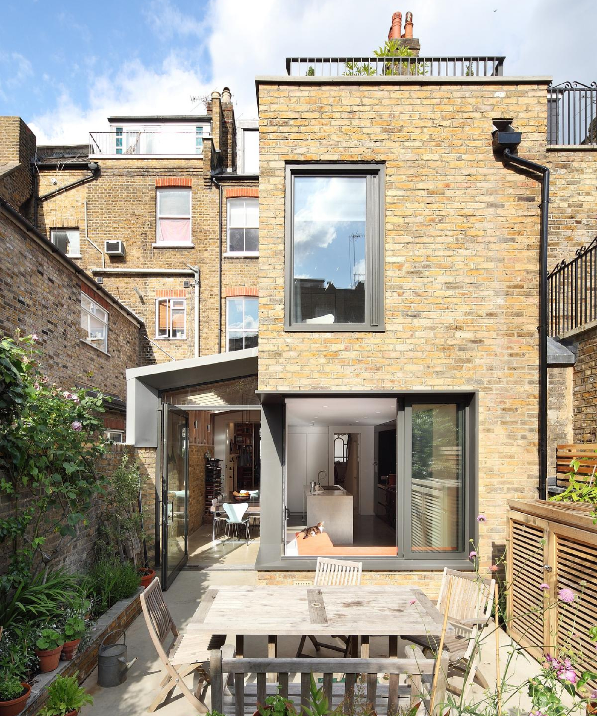 brick terraced house with side extension and corner glazing