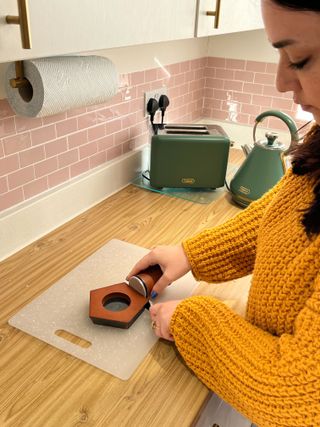 I am wearing a yellow jumper and using the roller on wooden my kitchen counter