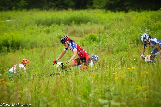 Lea Davison (Specialized) is marked by Katerina Nash in the tall grass