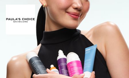 Model holding paula's choice skincare bottles