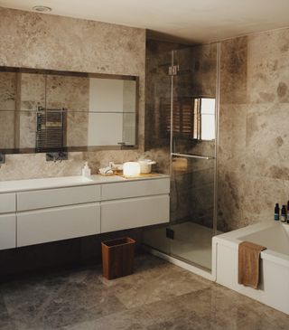 Bathroom interior with white cupboards and walk in shower