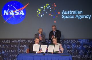 U.S. Secretary of Commerce Wilbur Ross, top left, and Australian Prime Minister Scott Morrison, top right, witness the signing of a letter of intent between NASA and the Australian Space Agency by NASA Deputy Administrator Jim Morhard, left, and Dr. Megan Clark, Head of the Australian Space Agency, right, Saturday, Sept. 21, 2019 at NASA Headquarters in Washington.