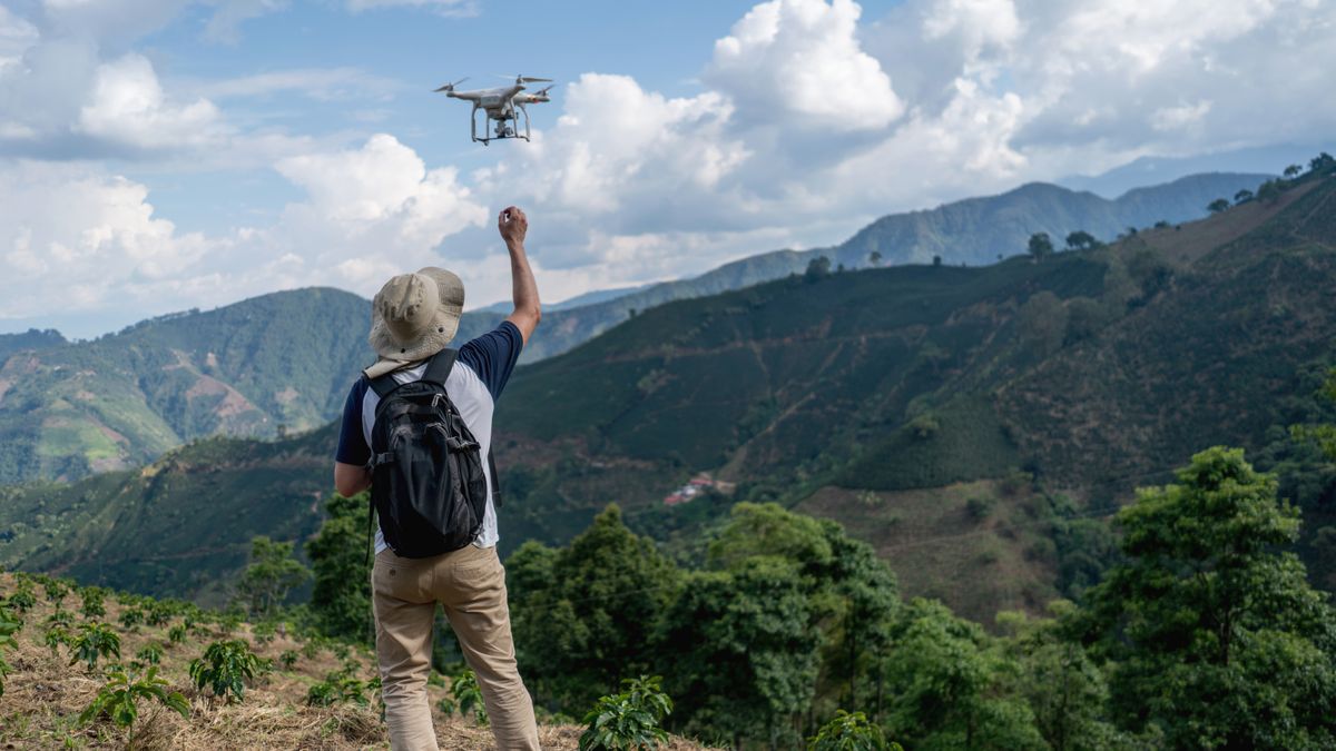 Man flying drone in countryside