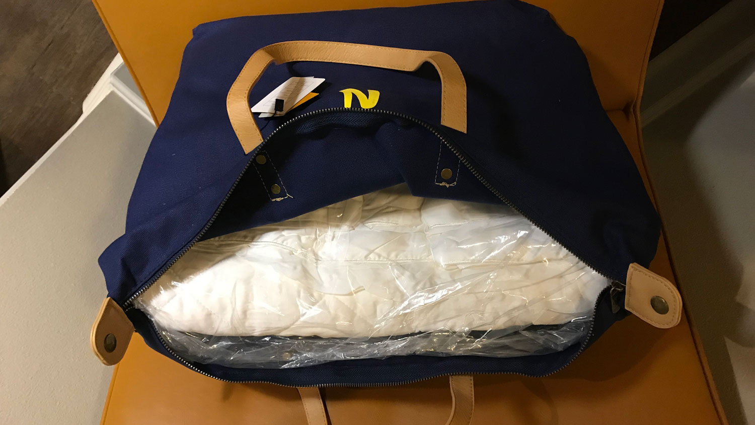 The Nolah Bamboo Mattress Pad in plastic wrap, in its bag