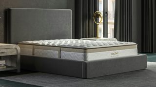 The Saatva Memory Foam Hybrid Mattress on a bed frame in a bedroom