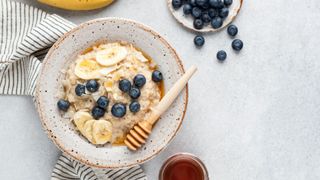 Bowl of porridge with honey, banana and blueberries