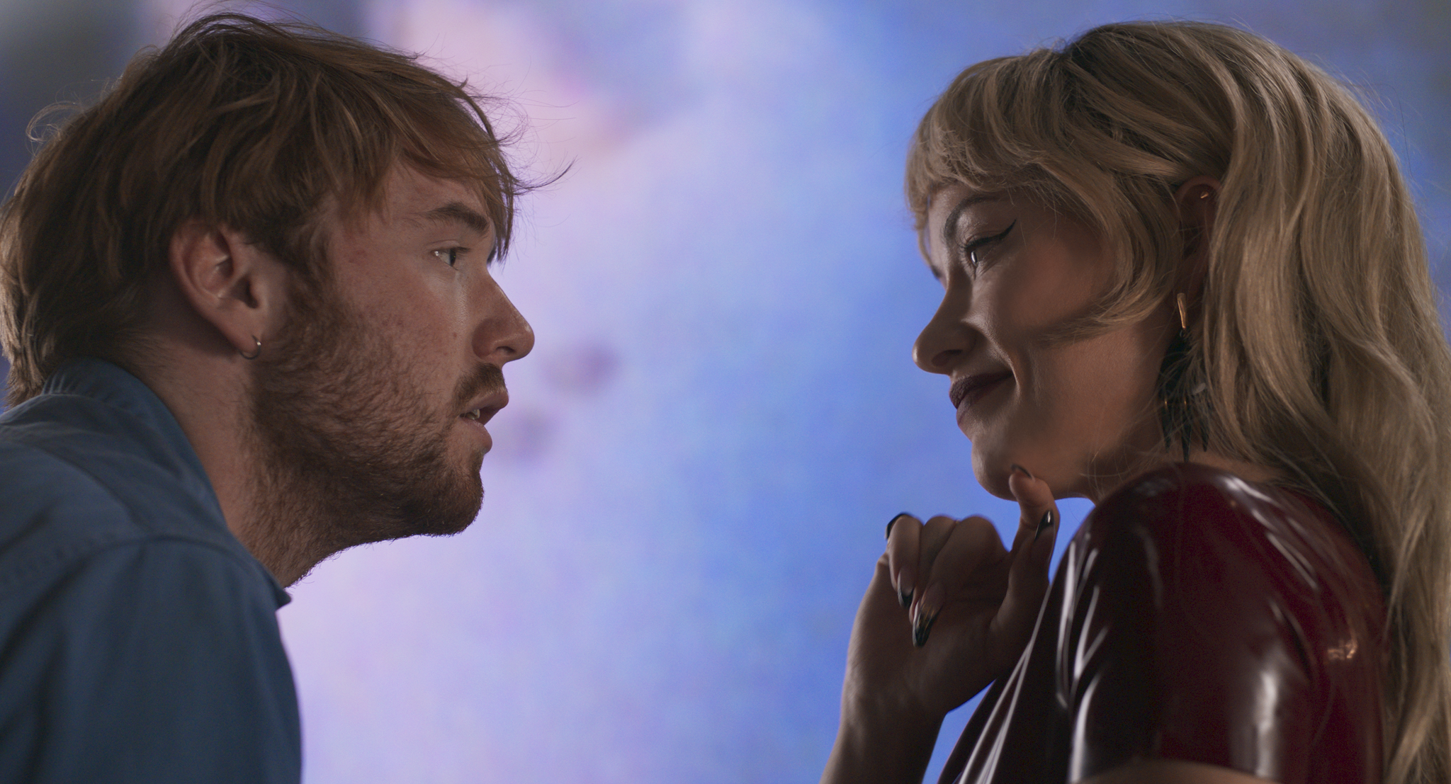 cooper hoffman looks into olivia wilde's eyes as she smiles and wears latex in a still from the movie i want your sex