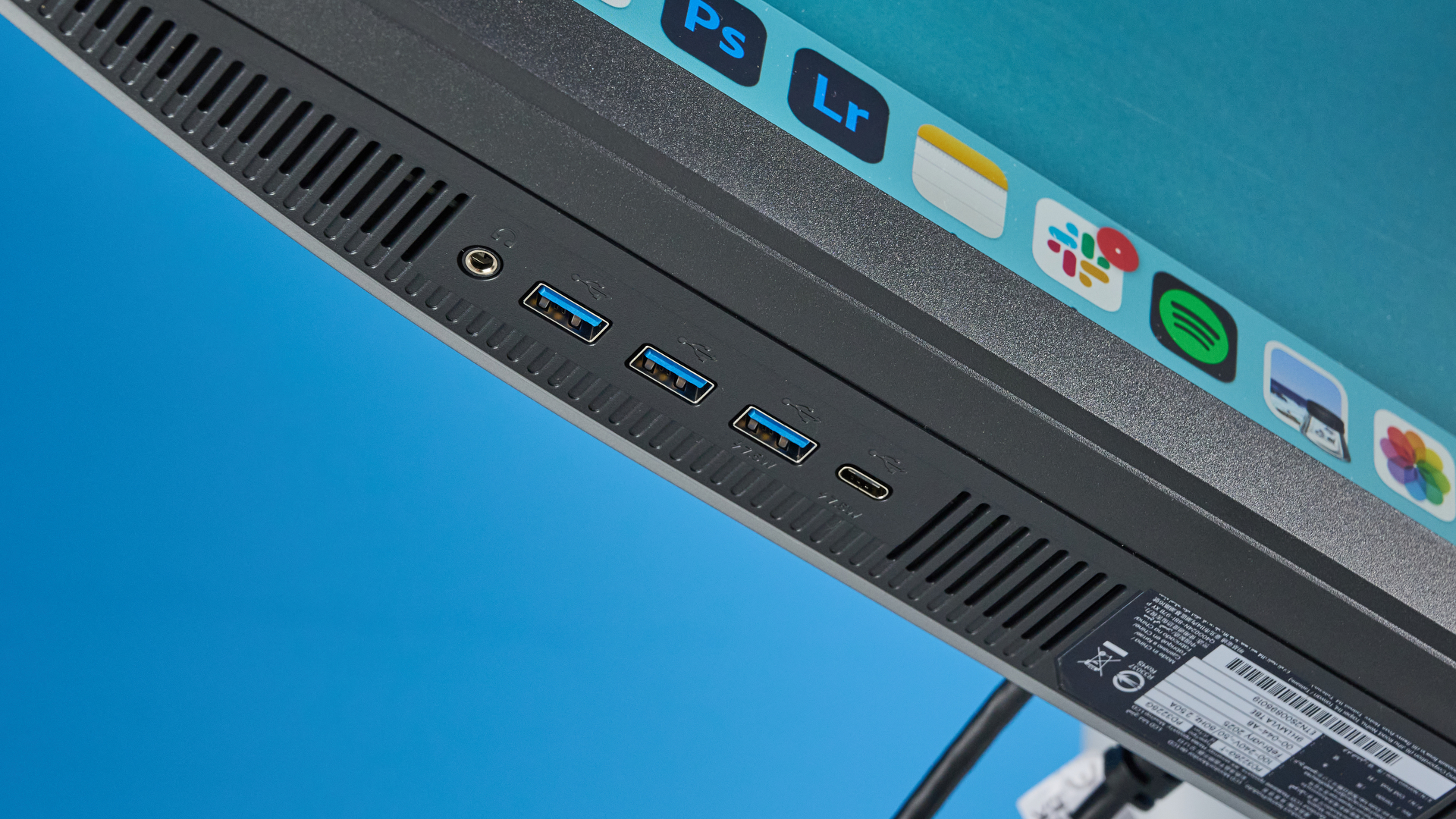 A photo of the BenQ PD3226G monitor in a blue-walled studio