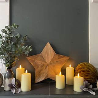 Wooden star in hearth with candles