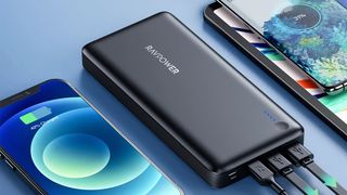 PD Pioneer 26800mAh Portable Charger next to iPhone and other gadgets.