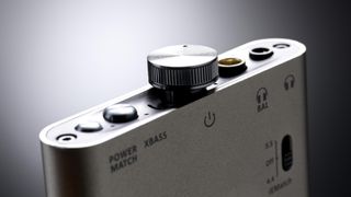 iFi hip-dac 3 close-up, showing the rotary volume knob and LEDs either side, on gray background