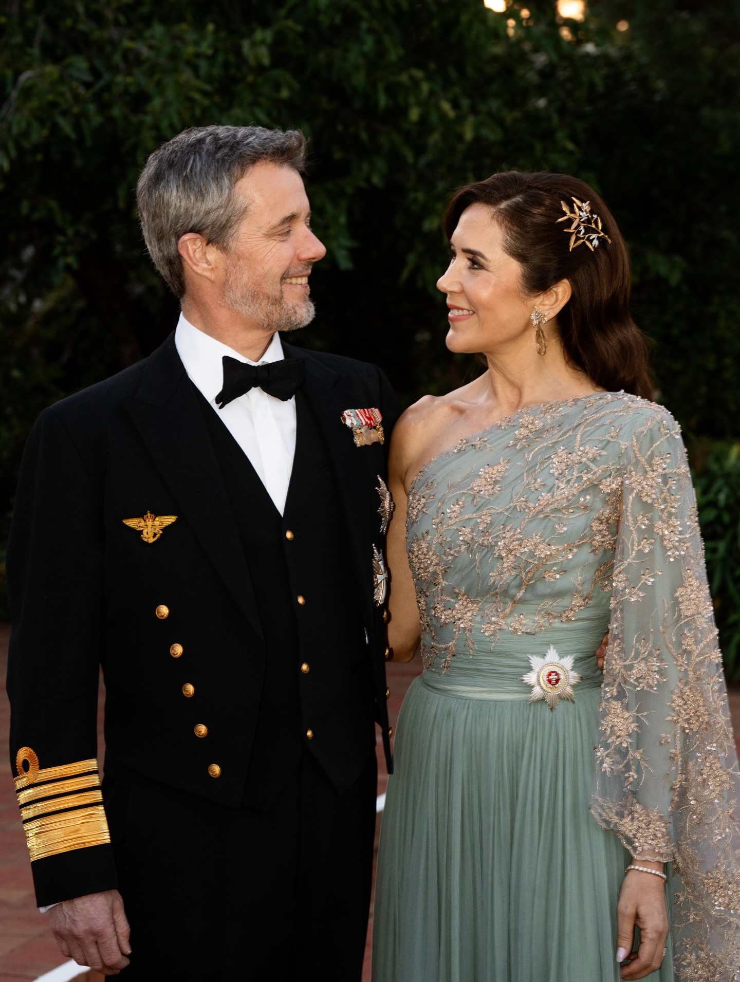 Queen Mary, in a mint green gown, and King Frederik smiling at each other