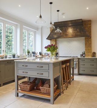 a grey kitchen with large kitchen island with drawers and seating