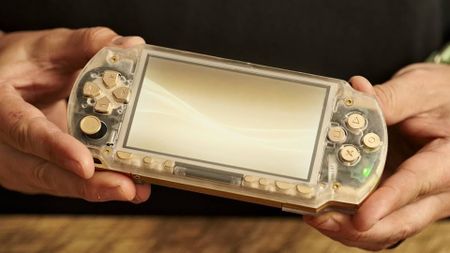 Hands holding custom brass and acrylic PSP handheld.