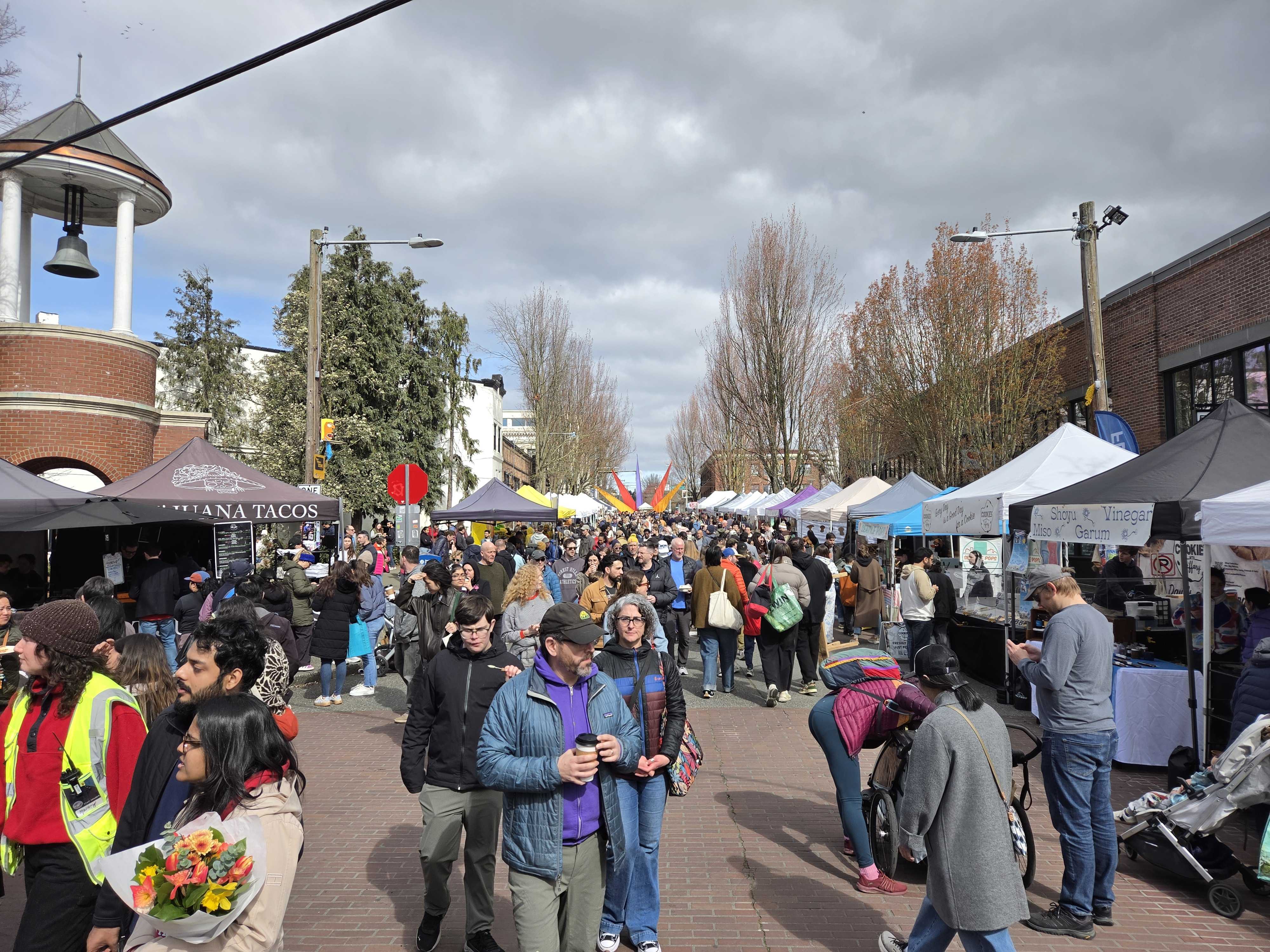 A busy street filled with people and tents
