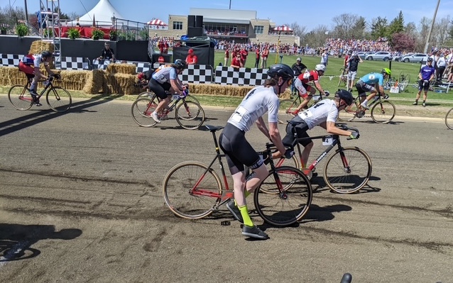 Jake Richards (centre) dismounts in an exchange with his Gray Goat Cycling teammate at a Little 500 race