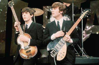 Paul McCartney and John Lennon holding their guitars.