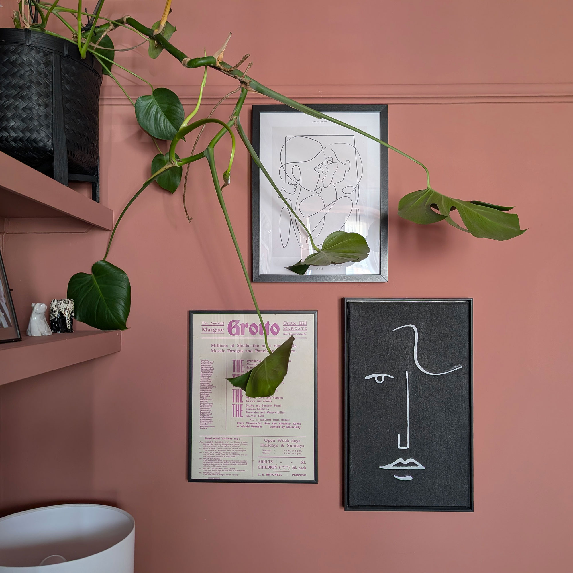 Three framed pictures on terracotta painted wall