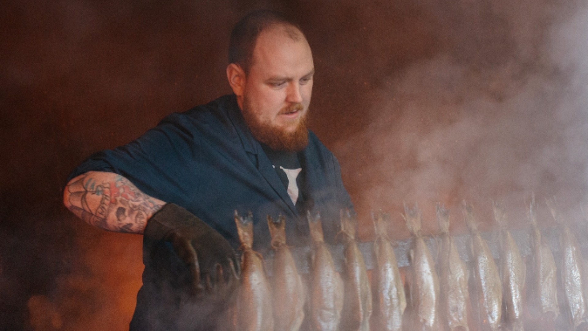 an image of a man smoking a rack of fish at the market