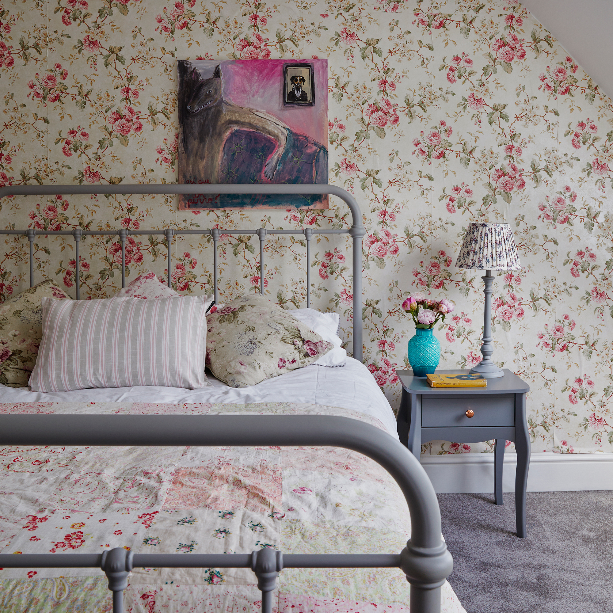 vintage style bedroom with floral wallpaper and grey painted metal bedstead