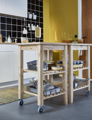 A kitchen with two mobile wooden kitchen carts