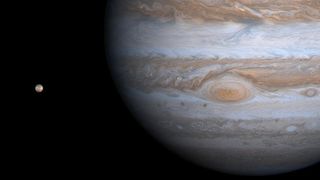 A picture of Jupiter and its moon Io, on the left. It was taken by NASA's Cassini spacecraft on Dec. 1, 2000. It shows details of Jupiter's Great Red Spot and other features that were not visible in images taken earlier, when Cassini was farther from the planet