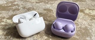 Galaxy Buds 2 Pro with AirPods Pro side-by-side on a stone surface