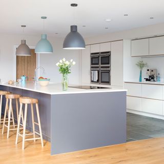 open plan grey and white kitchen with large island and wooden bar stools