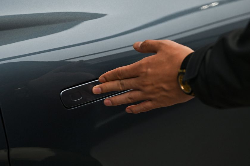 A hand over a concealed car door handle