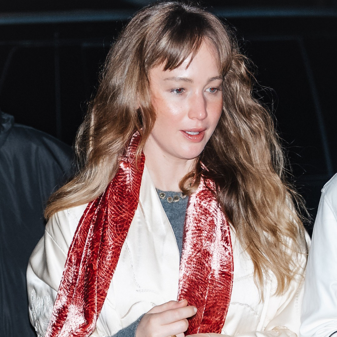 Jennifer Lawrence wore a velvet scarf, a white coat, jeans, and furry flip-flops to a concert in NYC