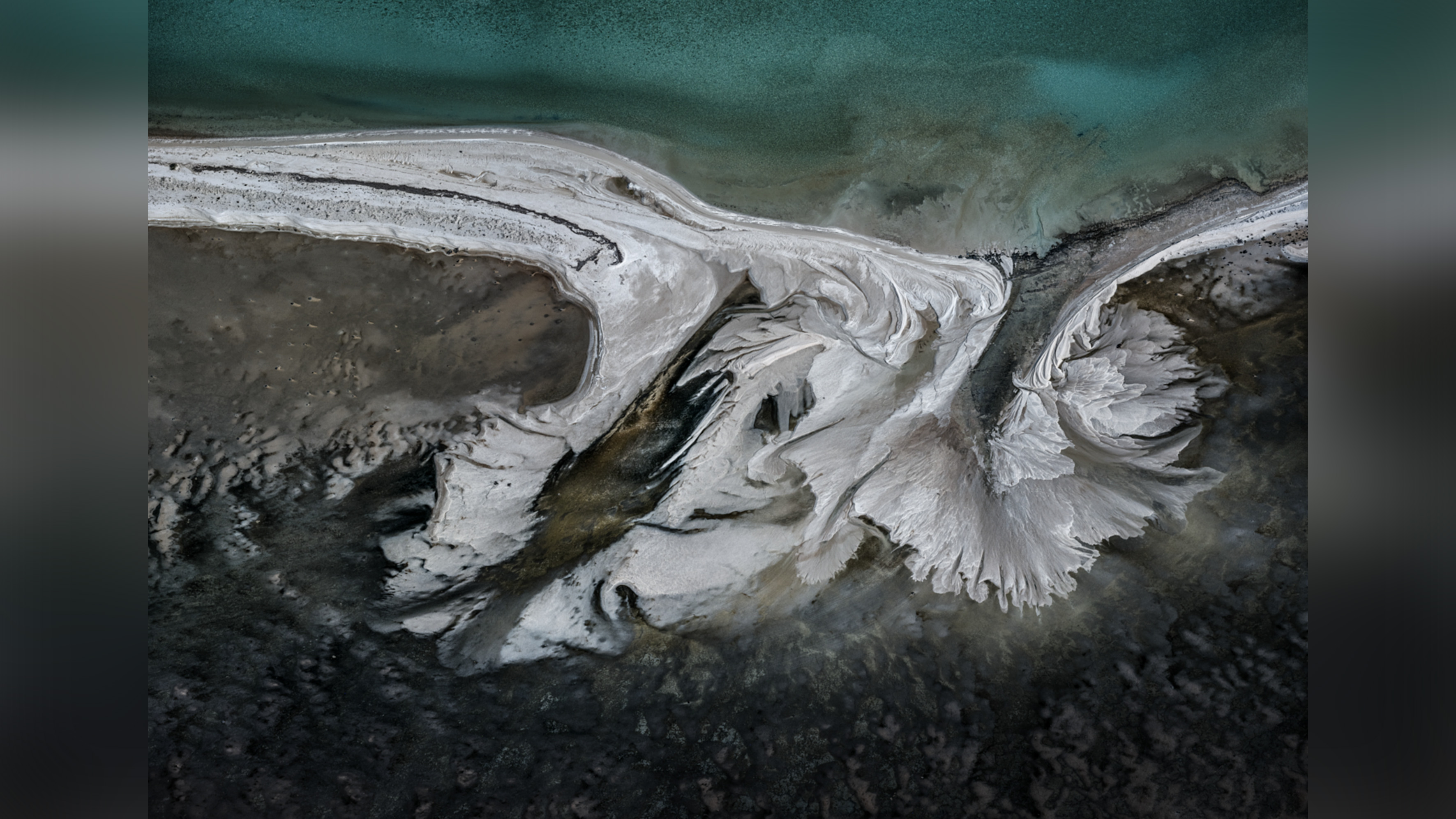 Colorful patterns in landscape produced by industrial mineral extraction. 