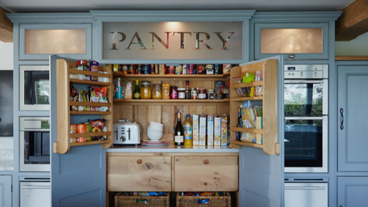 Open built-in kitchen pantry with blue doors and wood interior