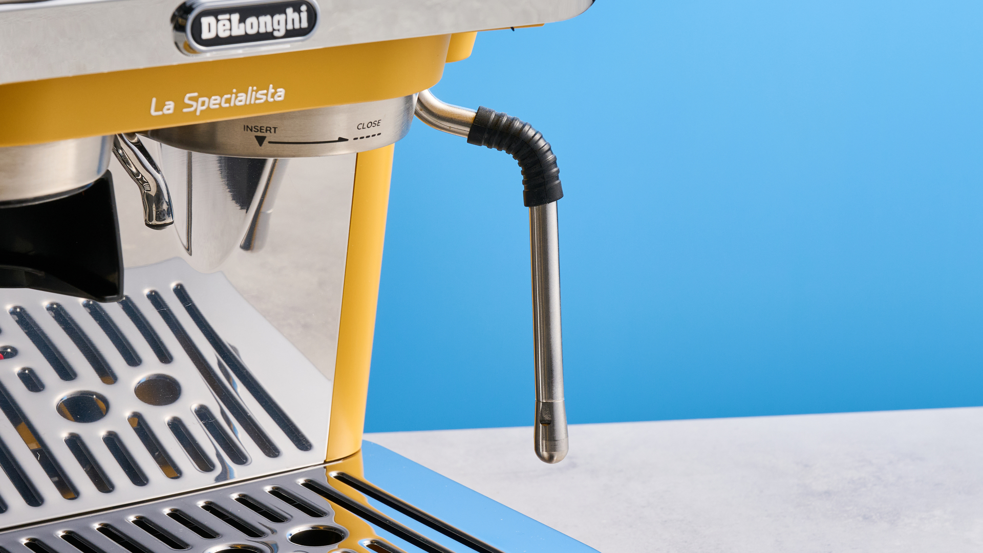 the de&#039;longhi la specialista arte evo special edition truestart edition, with yellow body, showing the espresso machine attachments like tamper, tamping collar, grinder, and control buttons