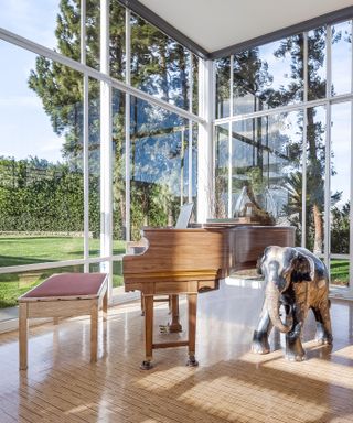Grand piano in large living space, surrounded by light