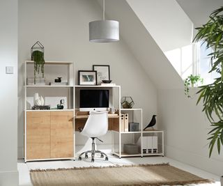 modular shelving system being used a desk in corner of loft