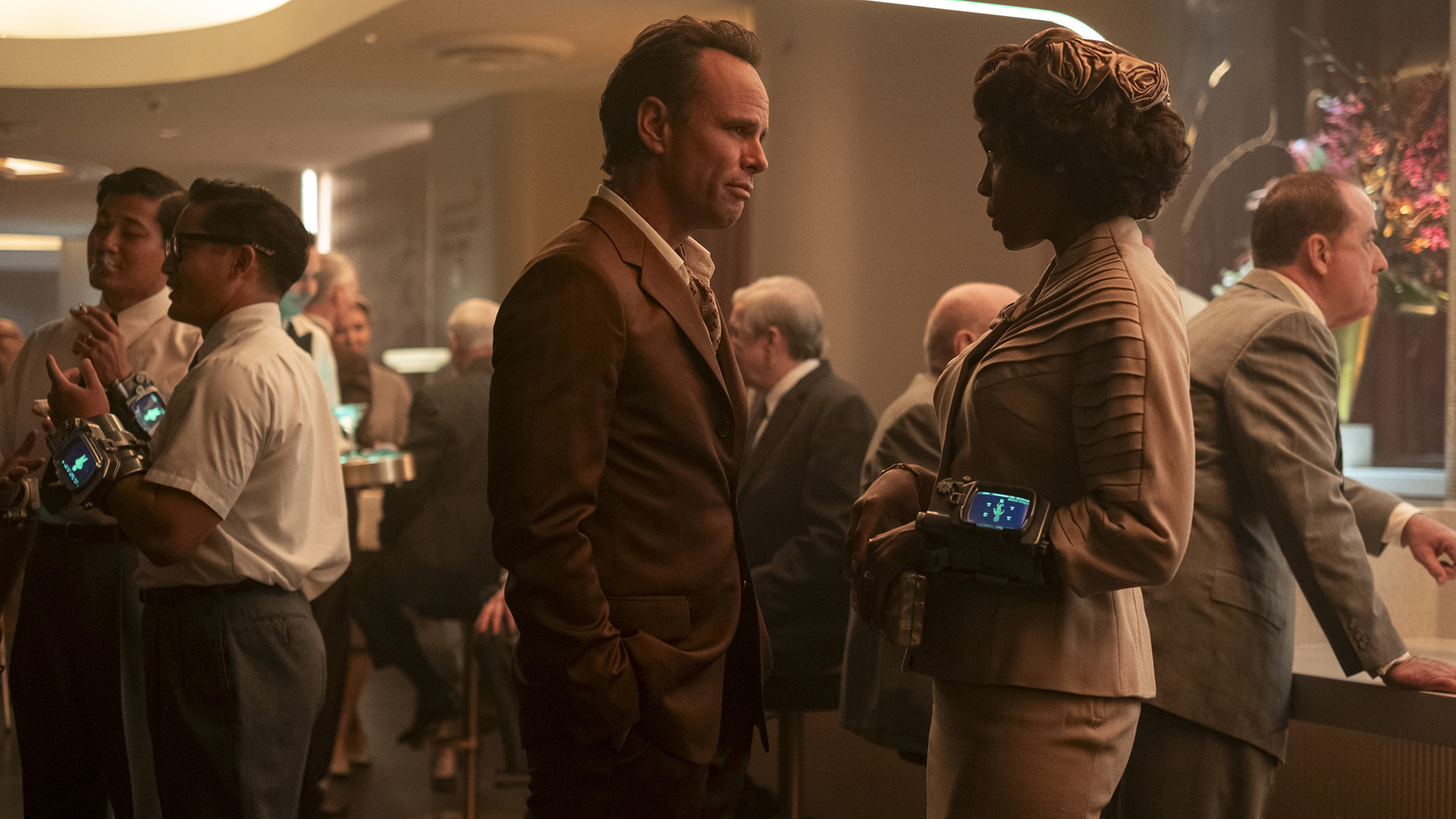 Cooper Howard standing with his wife Barb at a party in Fallout season 2