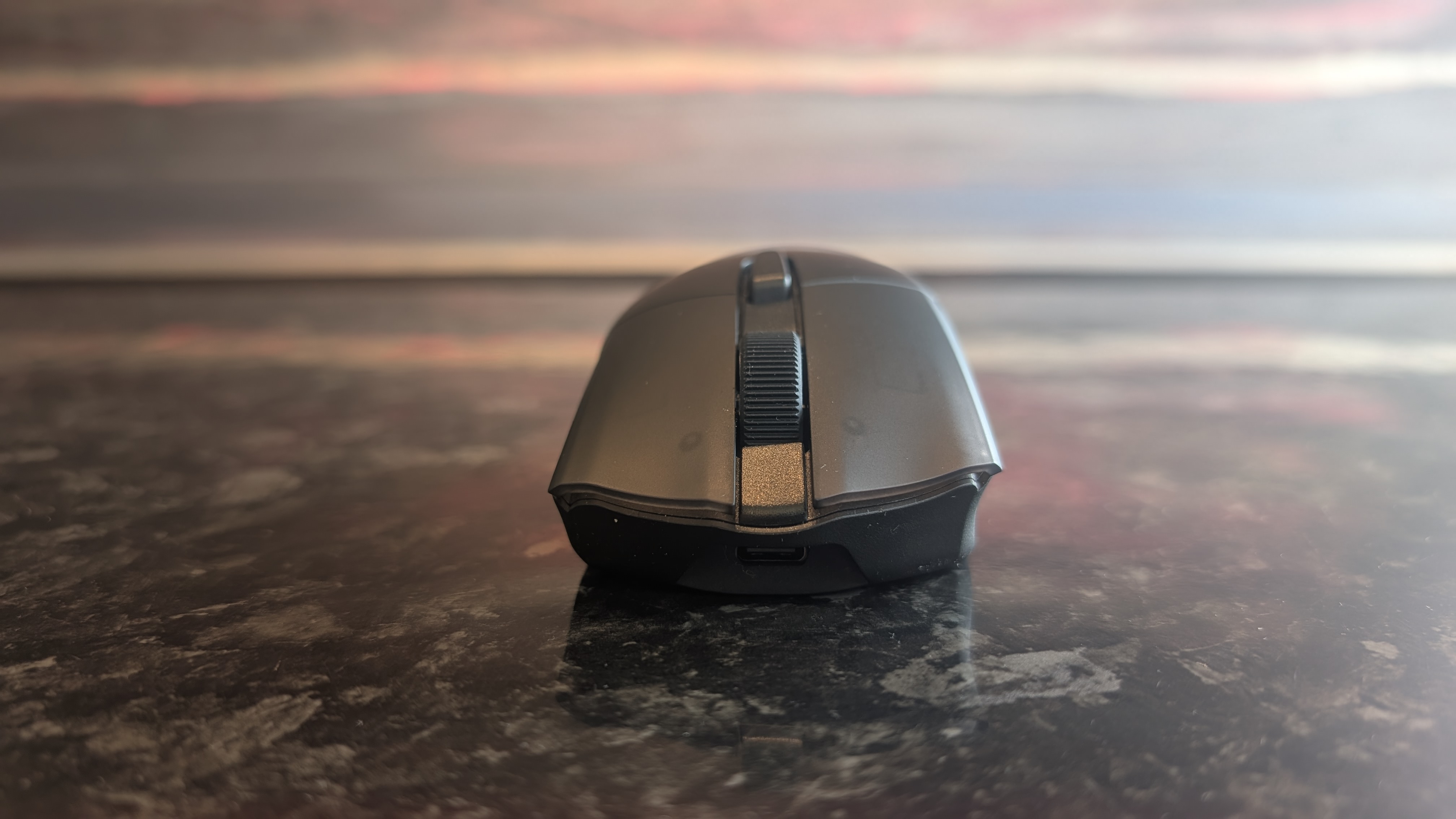 The Corsair Harpoon V2 Wireless gaming mouse pictured on a dark marble worktop.