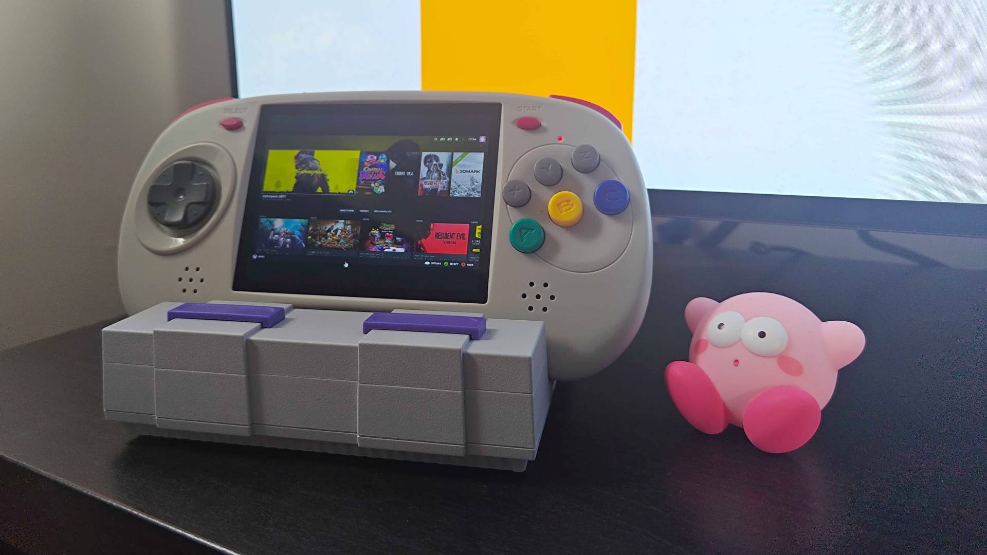 Anbernic RG ARC-D handheld with Steam Link Big Picture Mode on screen next to shocked Kirby figure and LG OLED TV in backdrop.