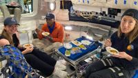 The Artemis 2 prime and backup crews practice eating in a simulator. From left: Jenni Gibbons, backup crew (Canadian Space Agency); Victor Glover, prime crew (NASA) and Christina Koch, prime crew (NASA). 