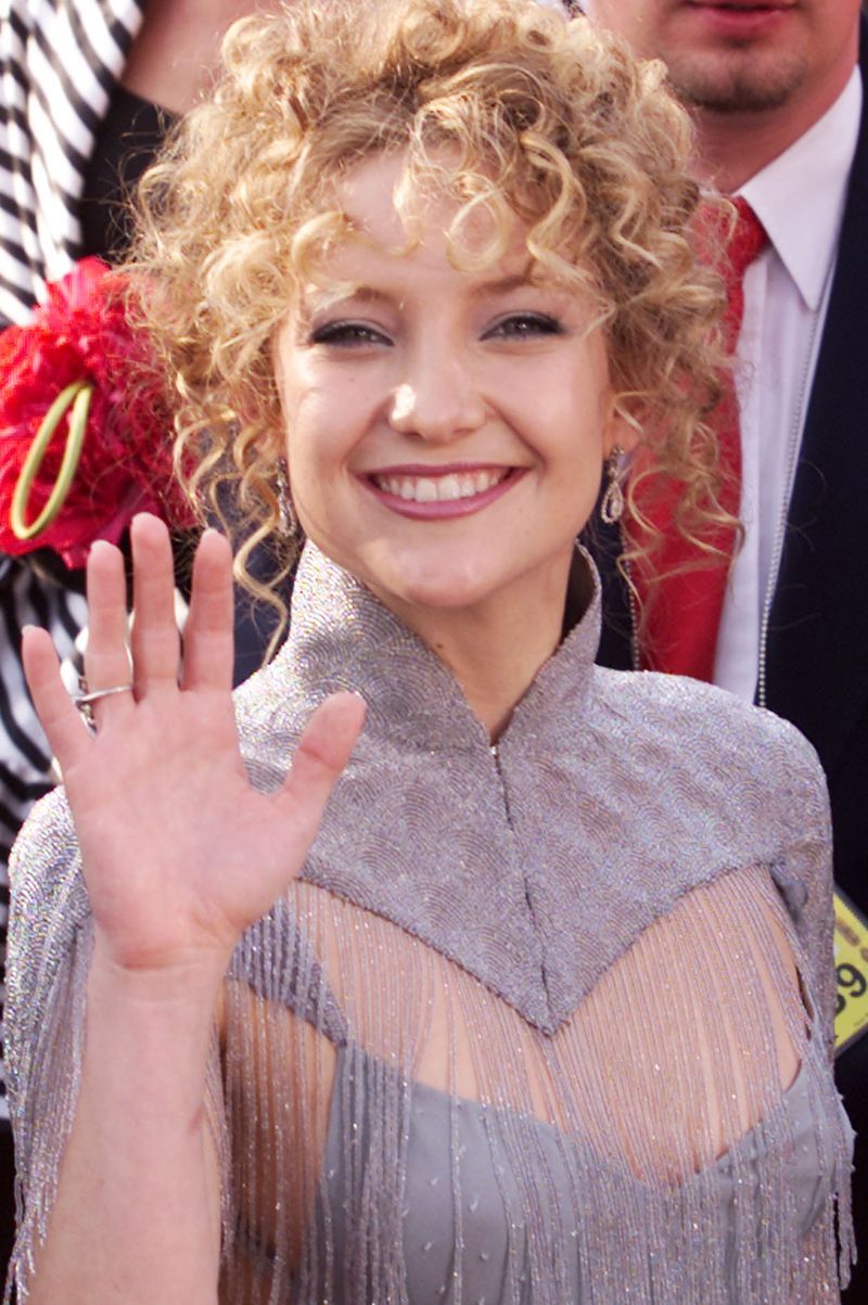 hair, facial expression, blond, hairstyle, smile, finger, event, suit, gesture, formal wear,