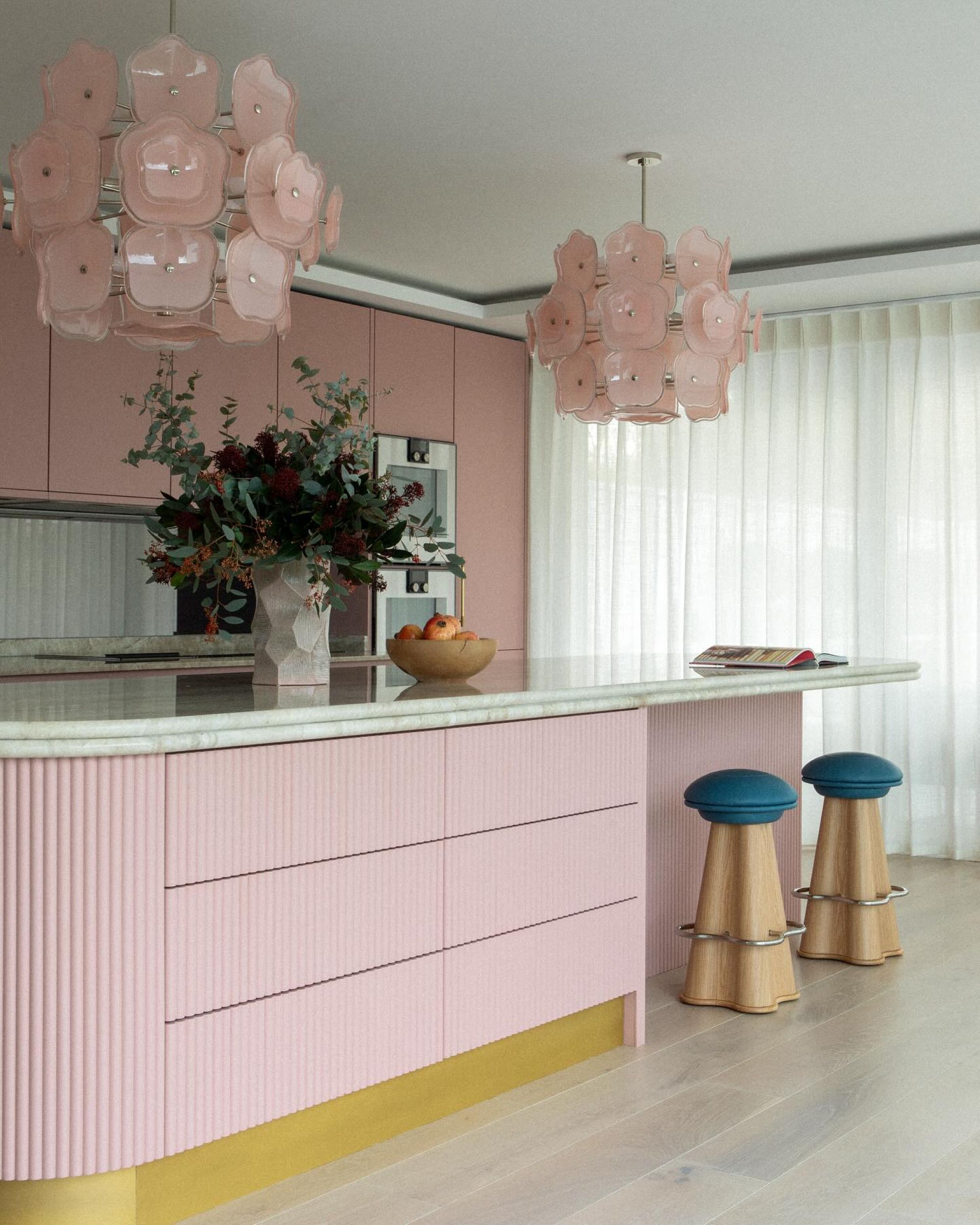 pink kitchen with floral pink pendants and teal blue stools