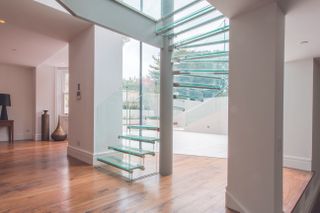 glass stairs that allow light to flood throughout the space by IQ glass