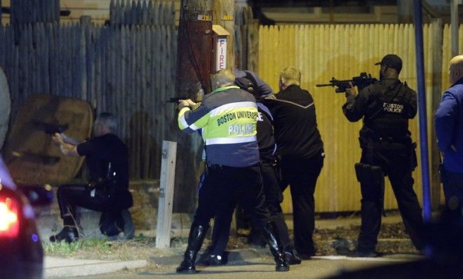 Police officers aim their weapons on April 19 in Watertown, Mass during a tense night of police activity.