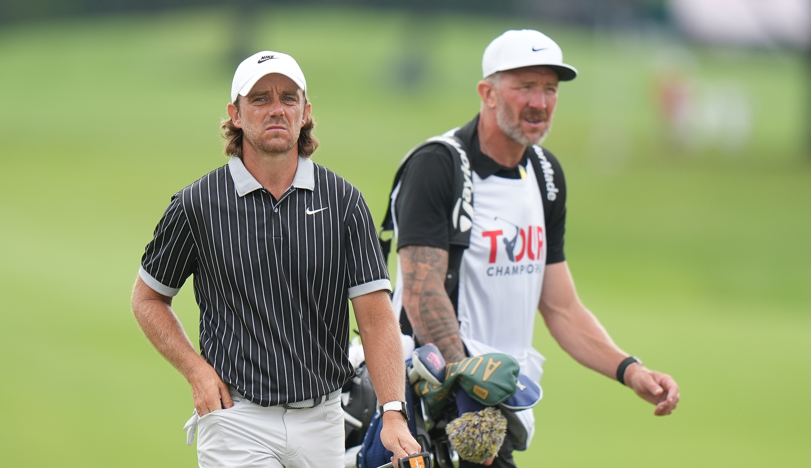 Tommy Fleetwood and his caddie walk on the fairway
